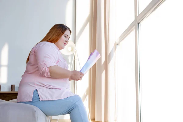 Mujer positiva alegre que se centra en la lectura — Foto de Stock