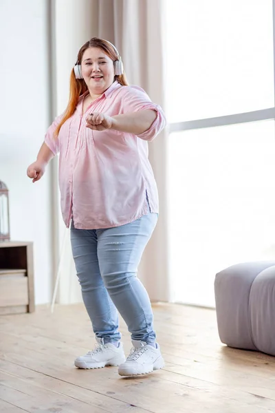 Mulher positiva agradável dançando para a música — Fotografia de Stock