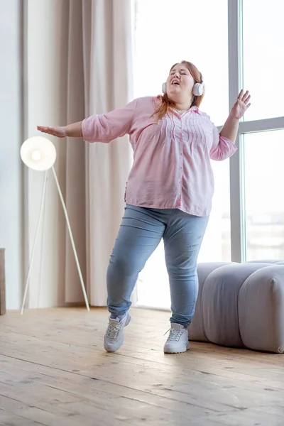 Delighted nice plump woman dancing at home — Stock Photo, Image