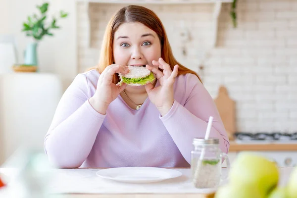 Fome gordinha mulher mordendo um saboroso sanduíche — Fotografia de Stock