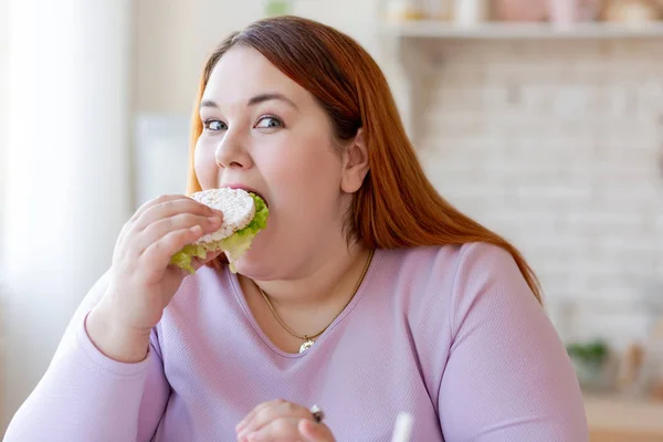 Agradável mulher gorda comendo um sanduíche saudável — Fotografia de Stock