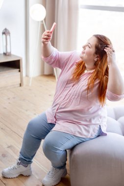 Neşeli pozitif tombul kadın saçlarını sabitleme