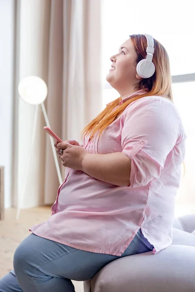 Radosna nadwaga młoda kobieta słucha muzyki — Zdjęcie stockowe