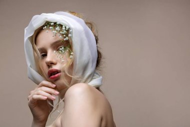 Model yüz yakın çiçekler ile modern dergi için poz