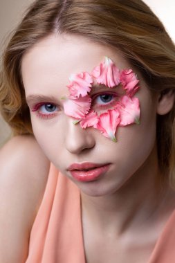 Yüze küçük pembe yaprakları gösteren pembe eyeshades ile model