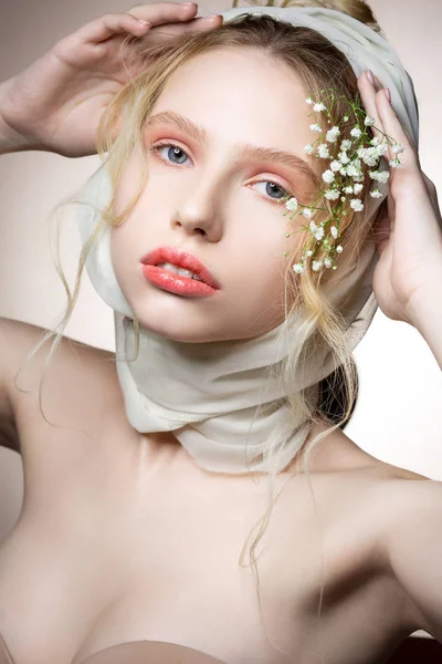 Blauäugiges Model in beigem BH posiert mit Blumen im Haar — Stockfoto