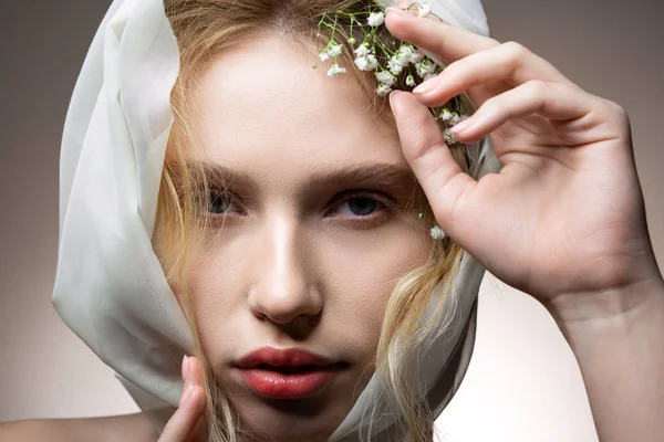 Modelo com sobrancelhas grossas posando com flores brancas no cabelo — Fotografia de Stock