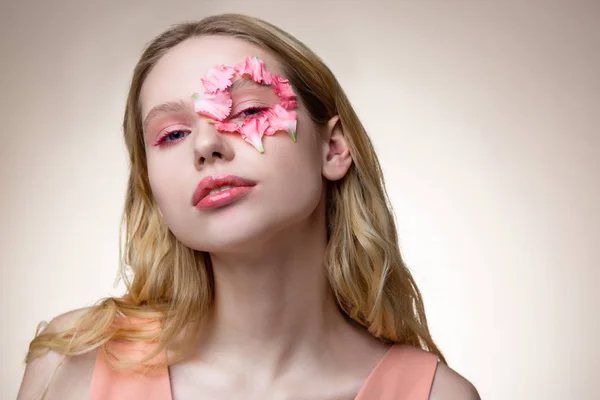 Tierna modelo rubia con pétalos rosados alrededor de su ojo — Foto de Stock