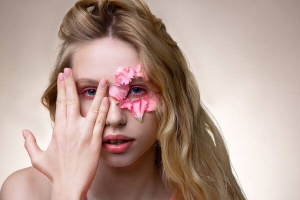 Young professional model with pink little petals on face