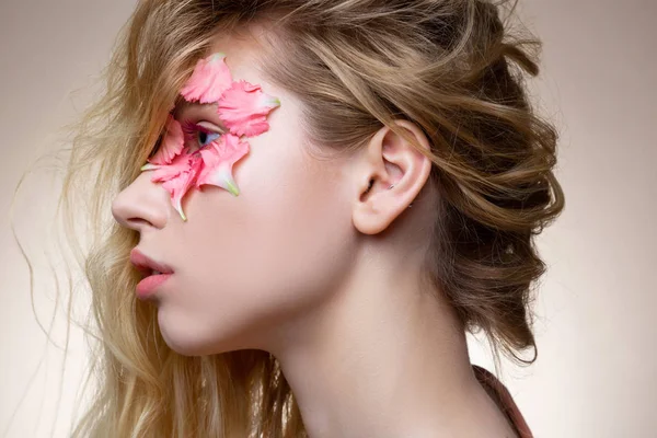 Attraktives Modell mit rosa Wimperntusche und Blüten in Augennähe — Stockfoto