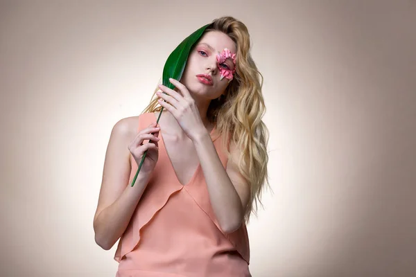 Modelo com cabelo ondulado longo posando em caráter de flor — Fotografia de Stock