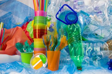 Kullanılan şişeler ve renkli pipetler arasına yerleştirilen plastik çatal bıçak yığını