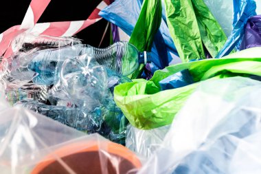 Çanta ve paketlerle yatan boş plastik şişeler