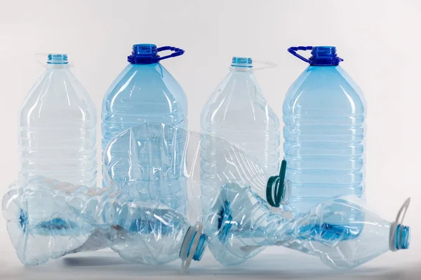 Aberto claro grandes frascos de plástico em pé atrás e alguns amassados — Fotografia de Stock