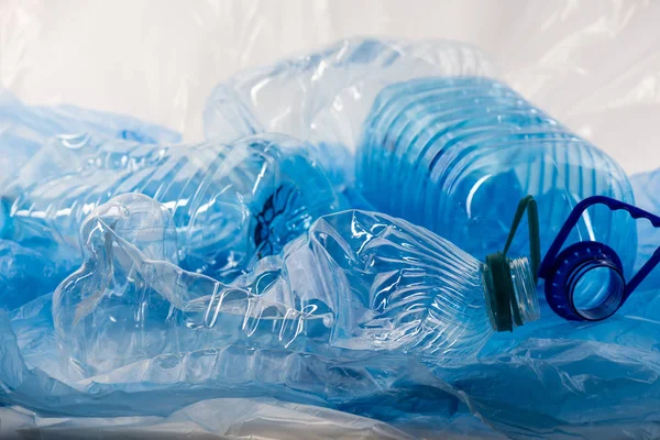 Pilha de garrafas de plástico transparente azul e sacos sendo jogados juntos — Fotografia de Stock