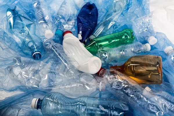 Bouteilles gâchées froissées colorées couchées dans une pile — Photo