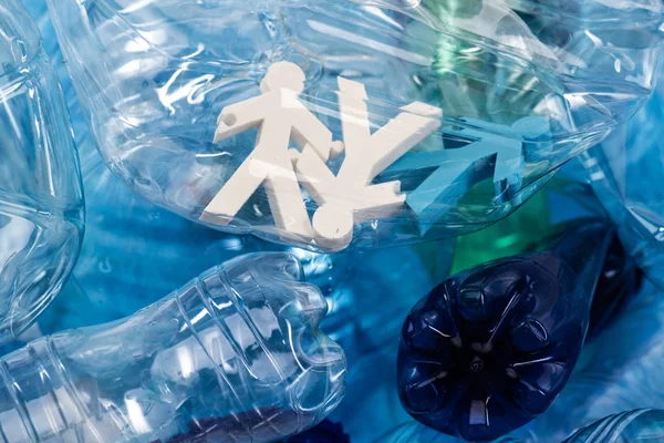 Colorful figures of people placed inside of plastic bottle — Stock Photo, Image