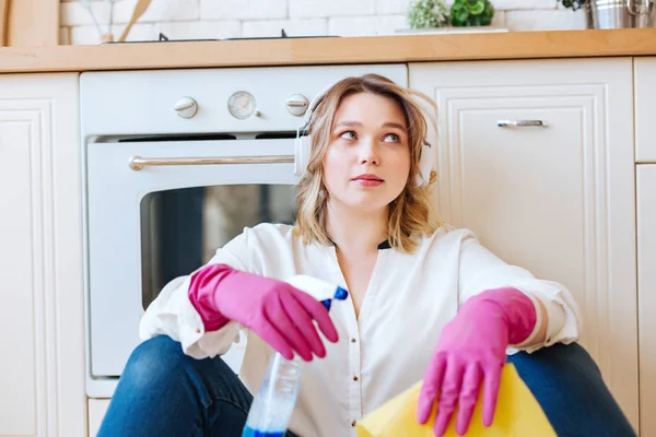 Angenehme junge Frau, die eine Pause vom Putzen macht — Stockfoto