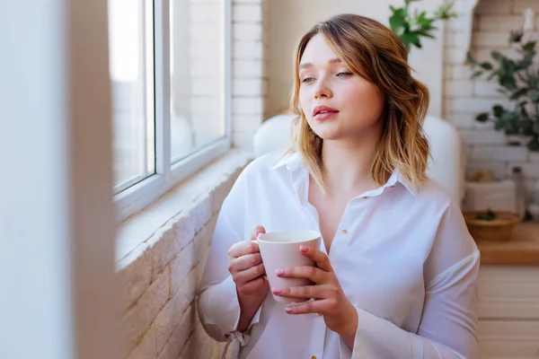 Aantrekkelijke mooie vrouw op zoek naar het raam — Stockfoto