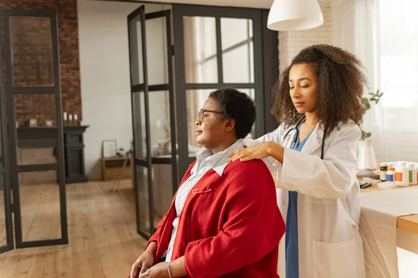 Medical attendant making some massage for woman after surgery — Stock Photo, Image