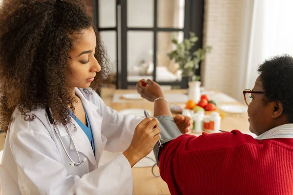 Infirmière À La Peau Foncée Bouclée Mesurant La Pression Pour Une Femme Qui Se Sent Mal — Photo