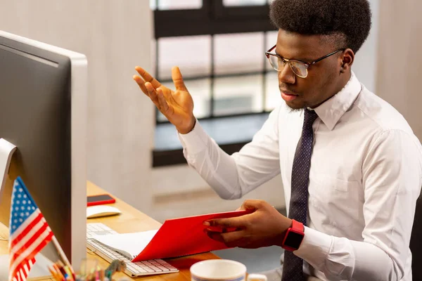 Serieuze jongeman die de financiële rapporten controleert — Stockfoto