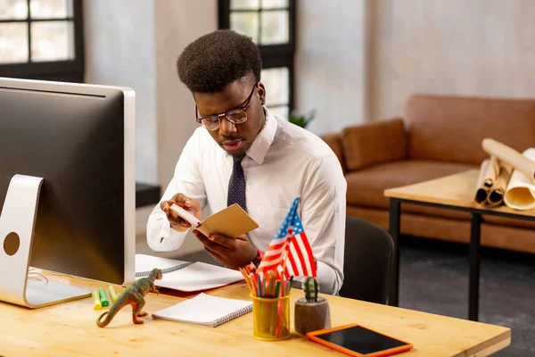 Agradável homem de cabelos escuros segurando seu caderno — Fotografia de Stock