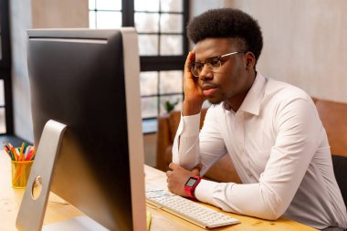 Ciddi kasvetli genç adam yanağını tutarak