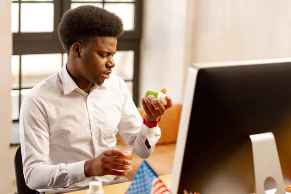 Trevlig afrikansk amerikansk man läser om piller — Stockfoto