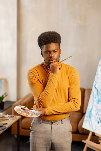 Creatieve jonge man denken over zijn schilderij — Stockfoto