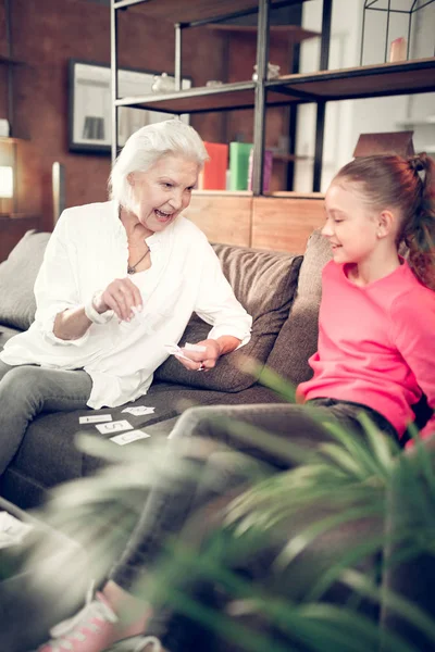 Granny and girl having much fun while doing homework together — Stock Photo, Image