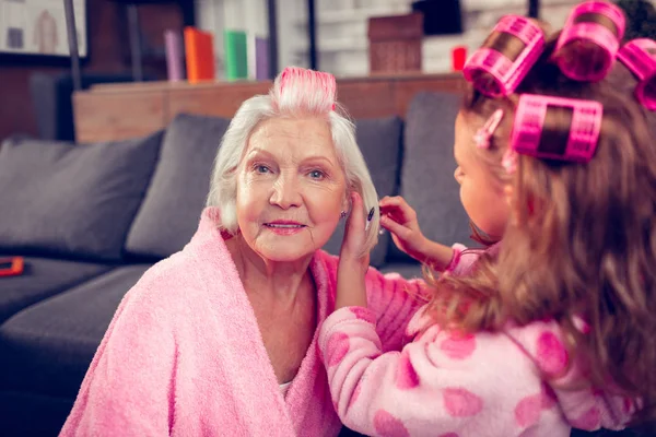 Senhora idosa sentindo-se bem tendo dia de beleza com neta — Fotografia de Stock