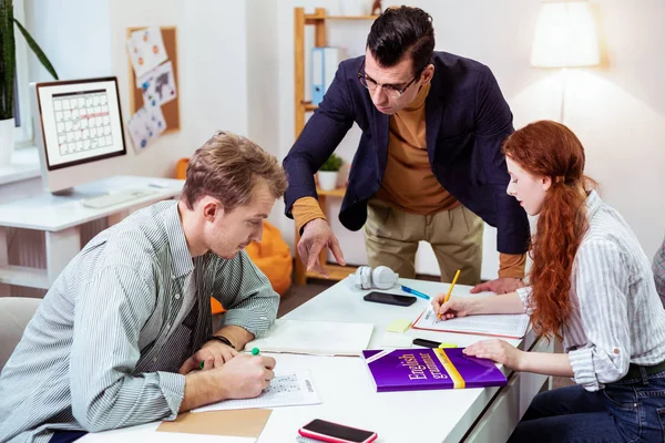 Profesor masculino profesional inteligente ayudando a sus estudiantes —  Fotos de Stock