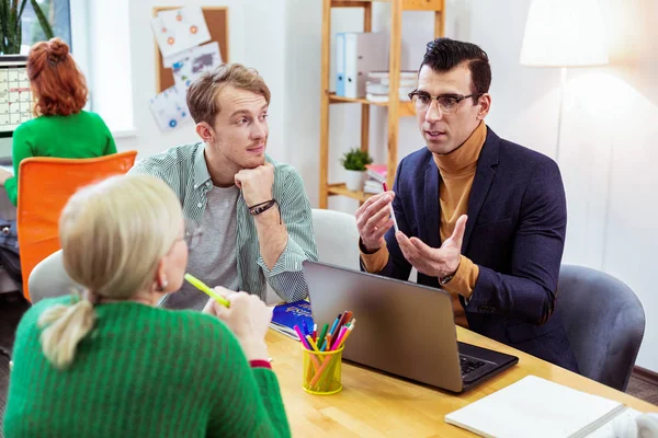 Ernsthafter netter junger Mann spricht über Arbeit — Stockfoto