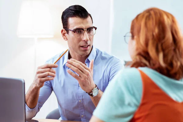 Smart mörkhårig man gestikulerande med sina händer — Stockfoto