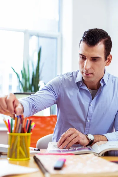 Sérieux gentil jeune homme prenant un crayon — Photo