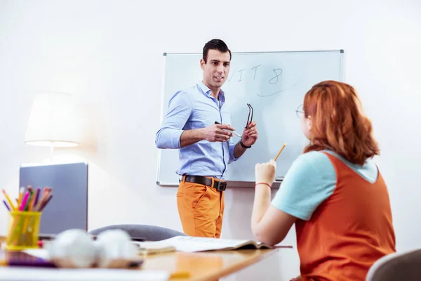 Nette junge Frau, die dem Lehrer Fragen stellt — Stockfoto