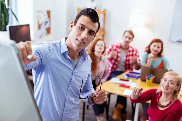 Knappe jonge man die naar het whiteboard kijkt — Stockfoto