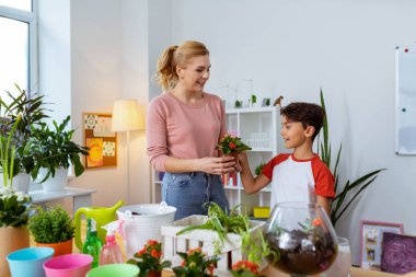 Botanik öğretmeni ile çiçek dikim koyu saçlı okul çocuğu