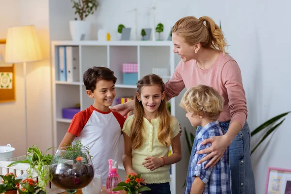 Blonde ecology teacher hugging her pupils after successful lesson — Stock Photo, Image