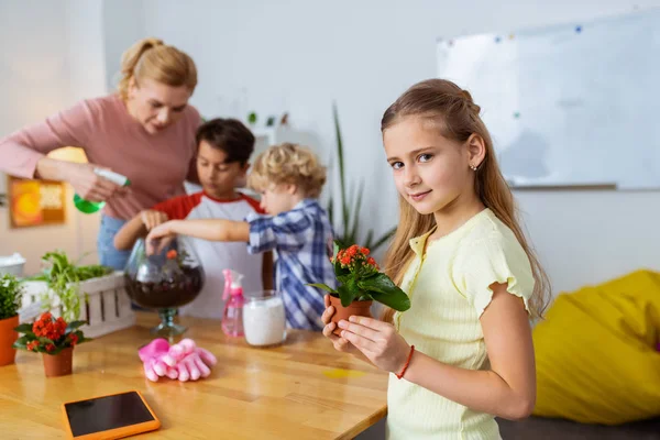 Estudante loira segurando vaso com flores na lição de ecologia — Fotografia de Stock