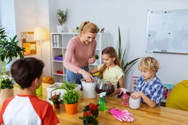 Alunos sentindo animado ao plantar flores com professor — Fotografia de Stock