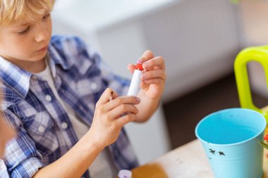 Sarı saçlı okul çocuğu boyama dan önce guaj tüp açılış