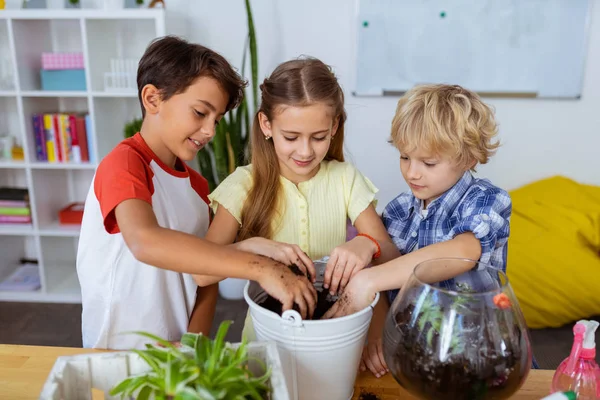 Alunos sentindo-se envolvidos no envasamento de flores e cactos na escola — Fotografia de Stock