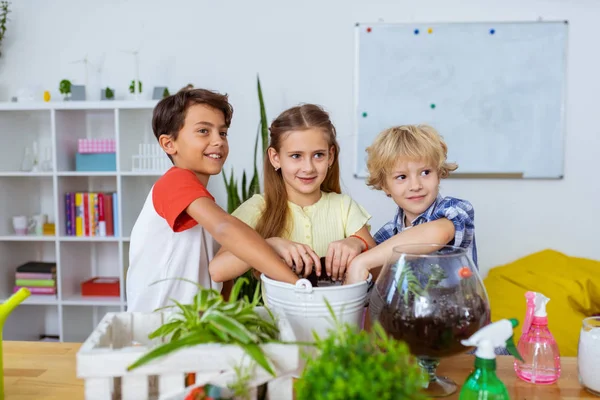 Aufgeregte Schulkinder beim gemeinsamen Eintopfen von Kakteen und Pflanzen — Stockfoto