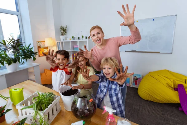 Pupils and teacher feeling happy after potting plants together — Stock Photo, Image