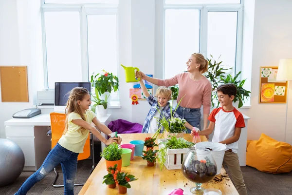 Gli alunni e l'insegnante si sentono allegri dopo aver innaffiato l'impianto in classe — Foto Stock