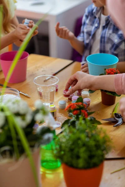 Pupilas tomando guache enquanto colore vasos de flores na aula de ecologia — Fotografia de Stock