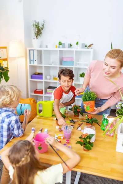 Three pupils attending ecology class coloring buckets for plants — Stock Photo, Image