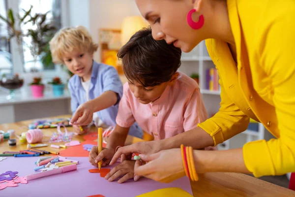 Ung lärare hjälper pojken att göra skärsår i form av hjärta — Stockfoto